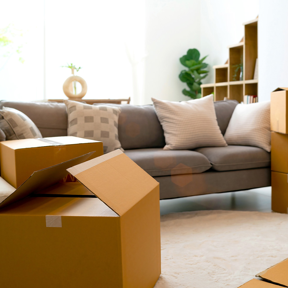 A sofa surrounded by moving boxes 